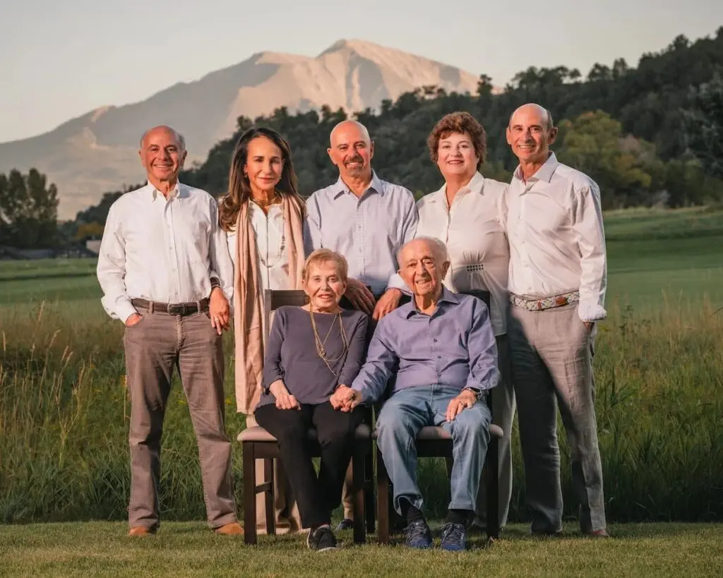 Family wearing coordinated summer outfits during Aspen mountain portrait session