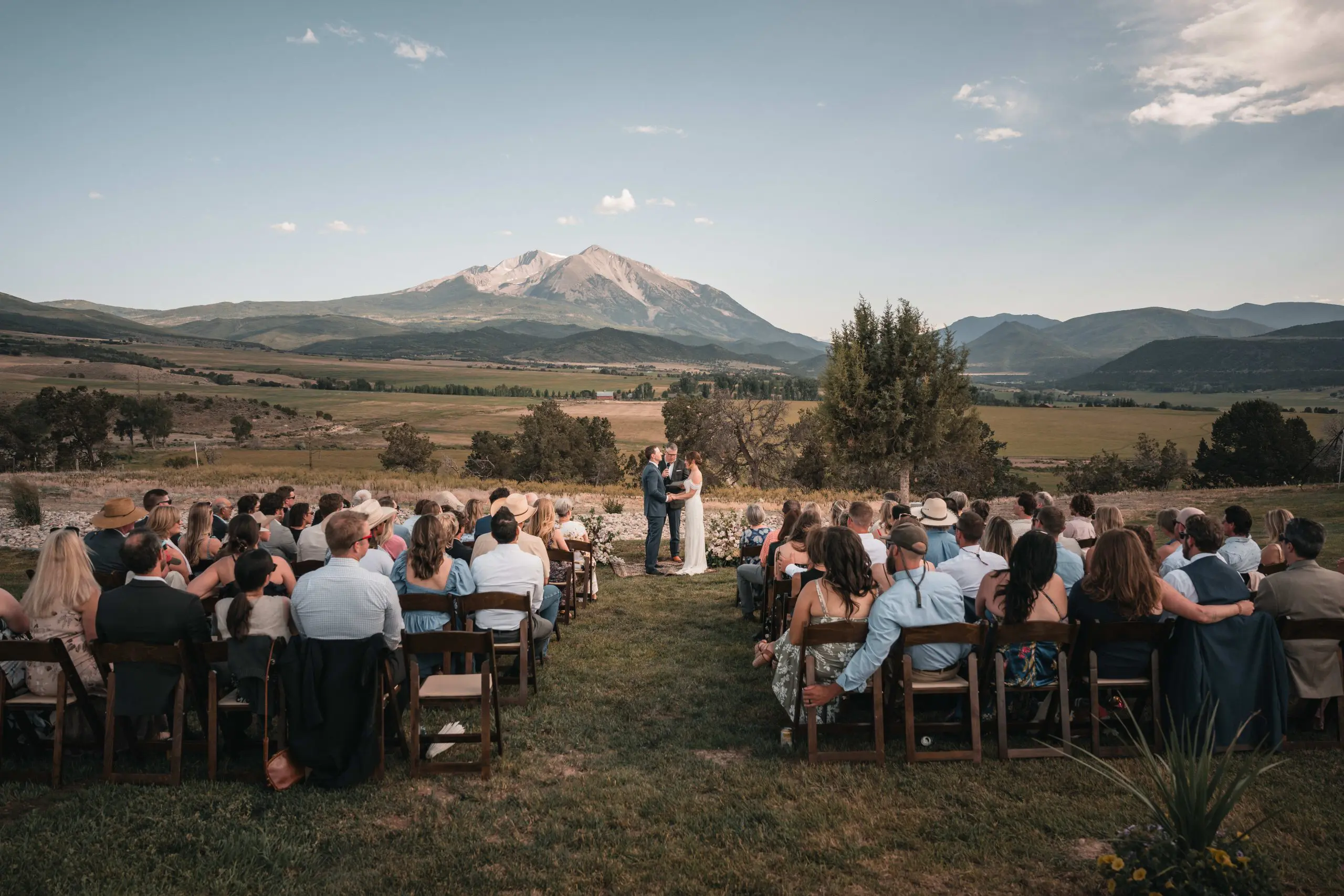 Aspen event photography of guests celebrating outdoors with mountain peaks behind them