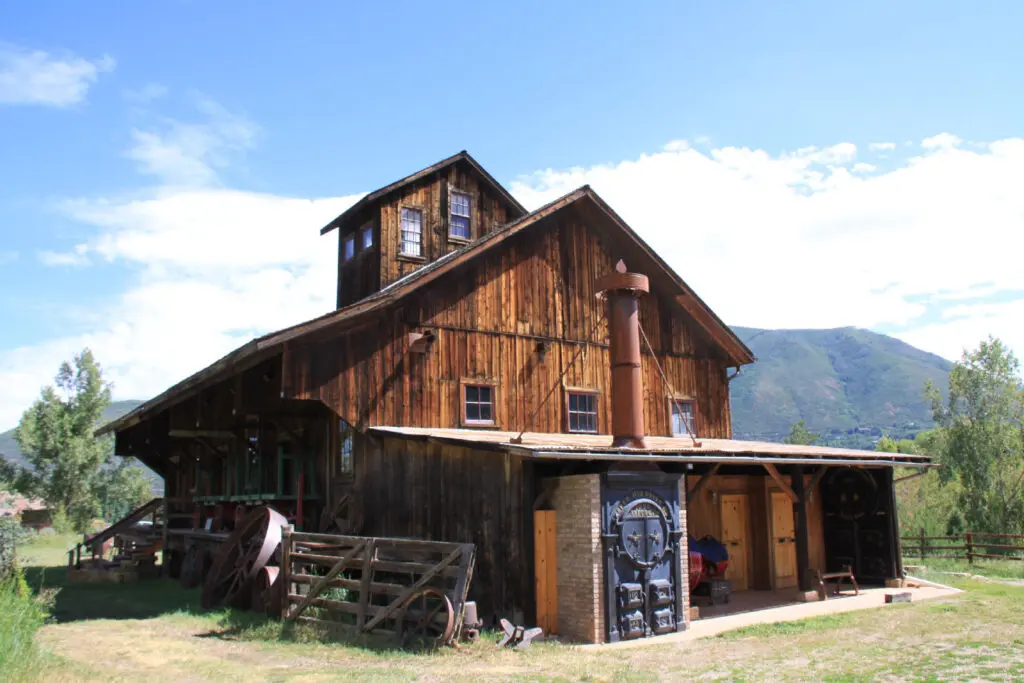 Weathered wooden barn at Holden Marolt wedding venue in Aspen with mountains behind