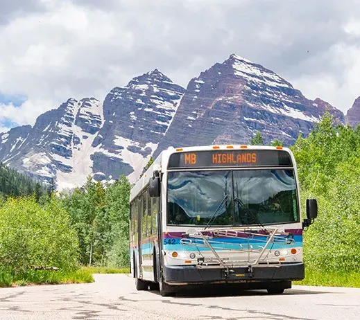 Shuttle navigating a mountain road S curve outside Aspen where drive times run longer than distance suggests