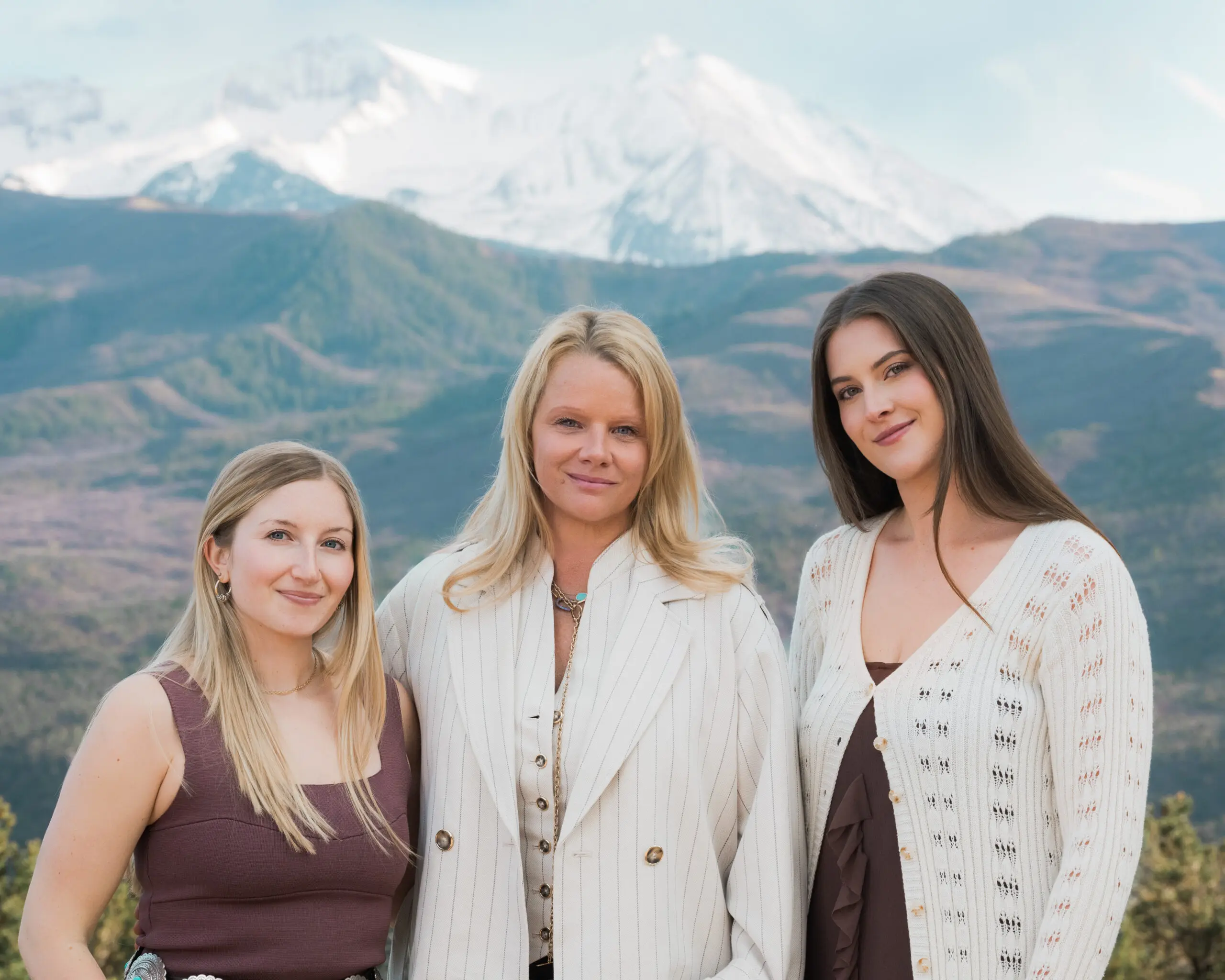 Three professionals photographed together with Aspen mountain views behind them.