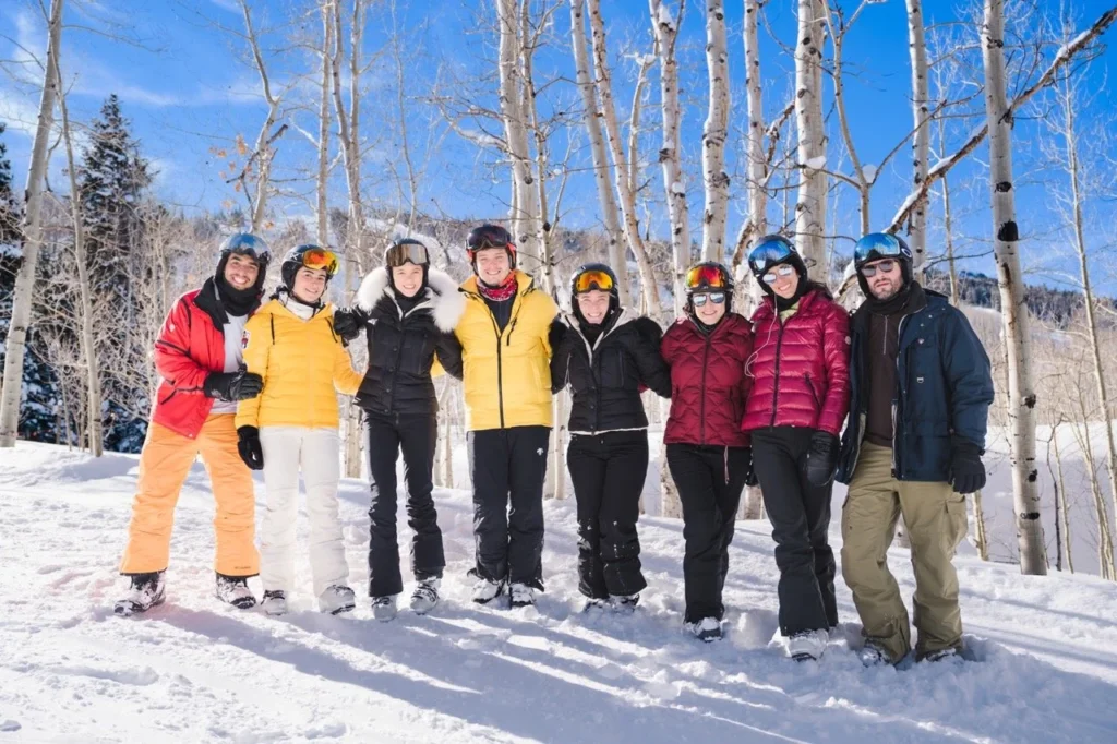 A group of friends posing in the snow and trees, captured by an Aspen ski trip portrait photographer.