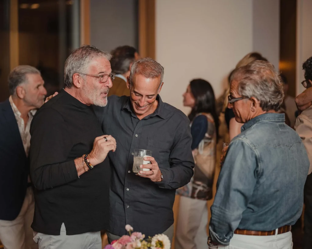 party goers chat together with drinks in hand