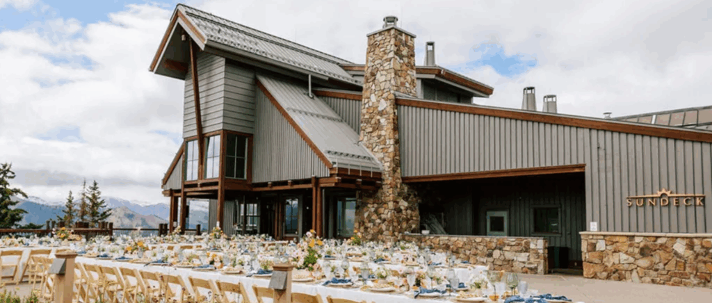 An elegant outdoor wedding reception setup at Little Nell, featuring beautifully arranged tables, floral décor, and stunning Aspen mountain views in the background.