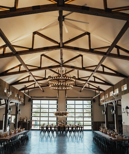 The indoor space at Spring Creek Ranch showcases rustic charm with exposed wooden beams, natural wood finishes, and a warm, inviting atmosphere for weddings or events