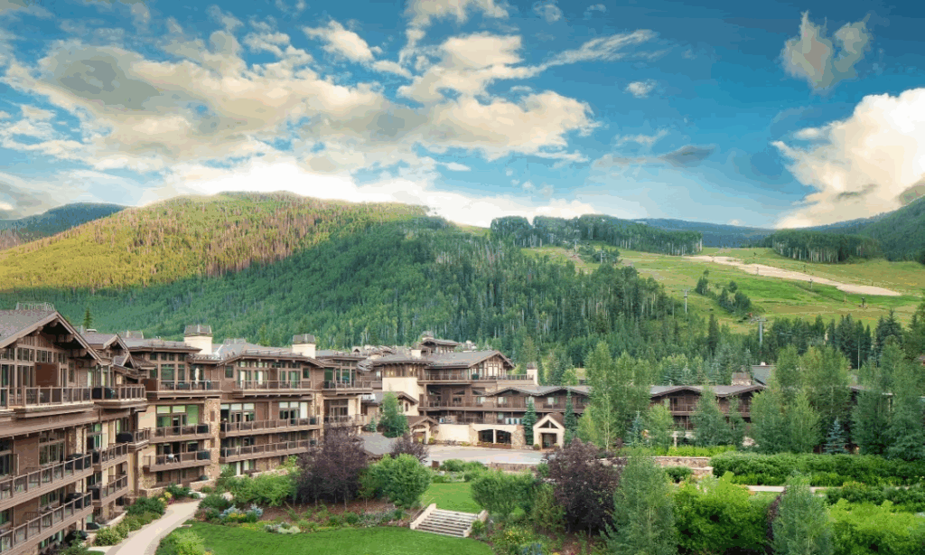 Luxury Vail resort surrounded by lush green mountains and summer alpine views in Colorado.