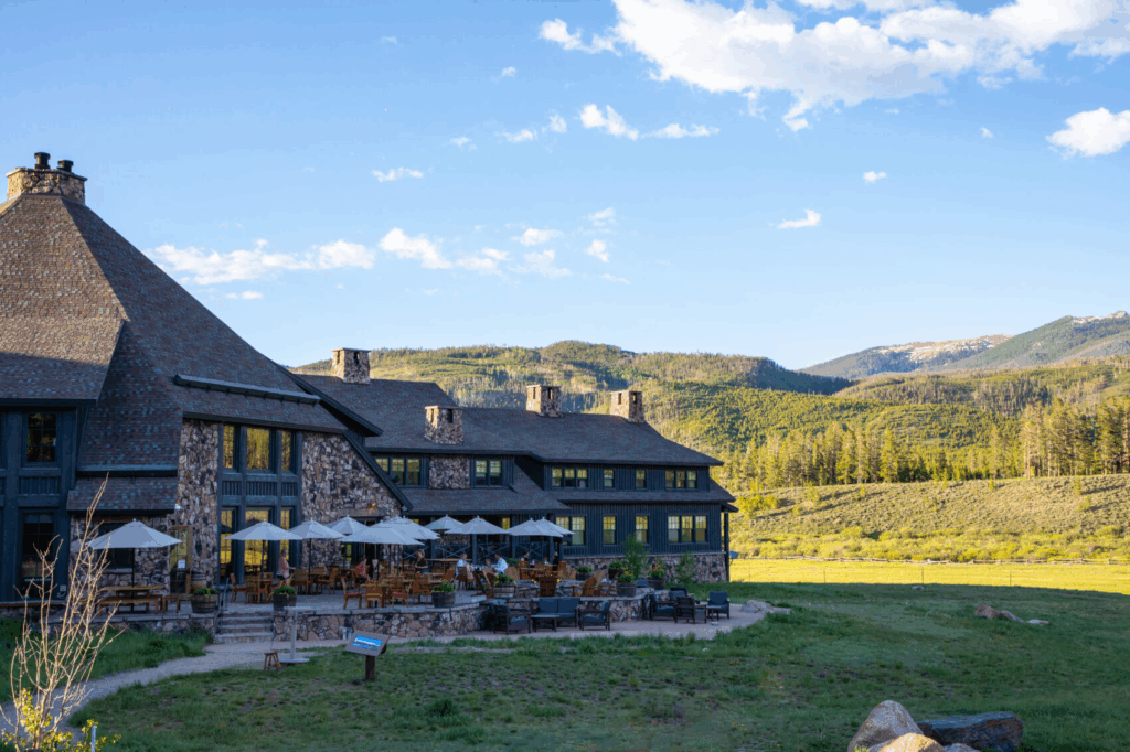 Exterior view of Devil’s Thumb Ranch in Tabernash Colorado with mountain scenery and outdoor patio seating, a popular Colorado wedding venue surrounded by open fields and alpine views.