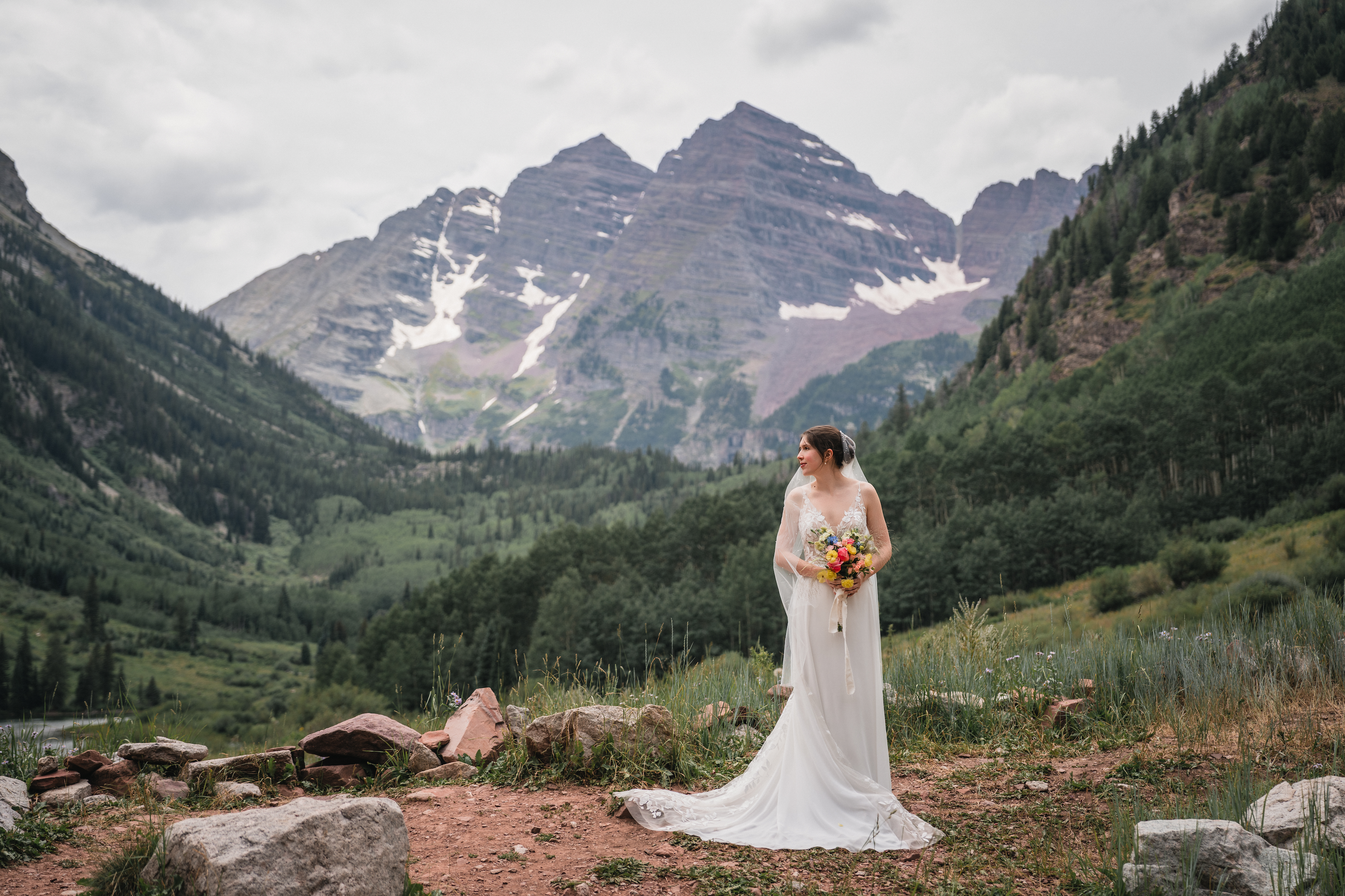 Bride taking a portrait in front of the scenic mountains of Maroon Bells Colorado.