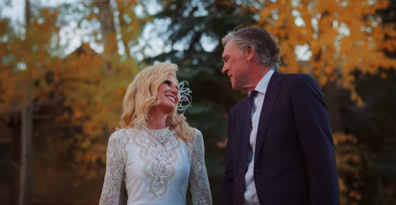 A bride and groom share a joyful look during their fall wedding video at McCabe Ranch, framed by vibrant golden autumn leaves and soft evening light.