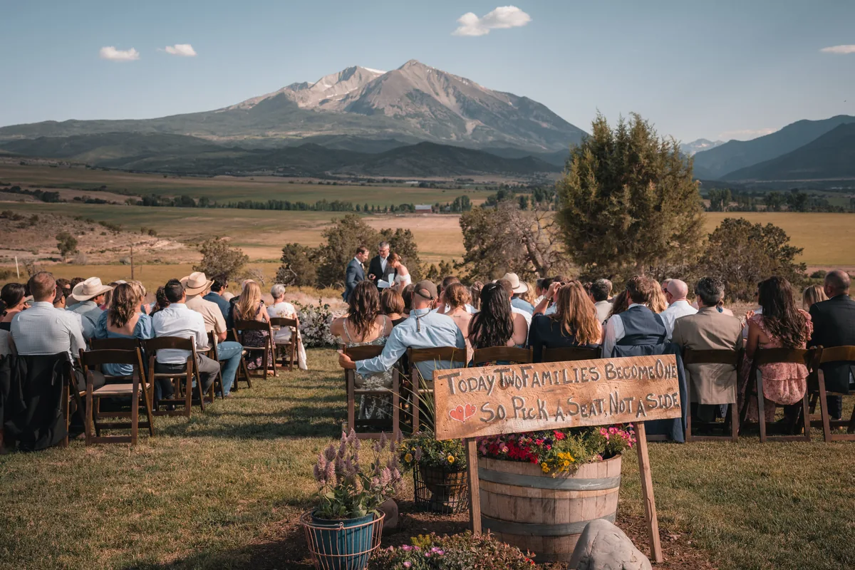 Ranch wedding ceremony spread across a valley below Mount Sopris