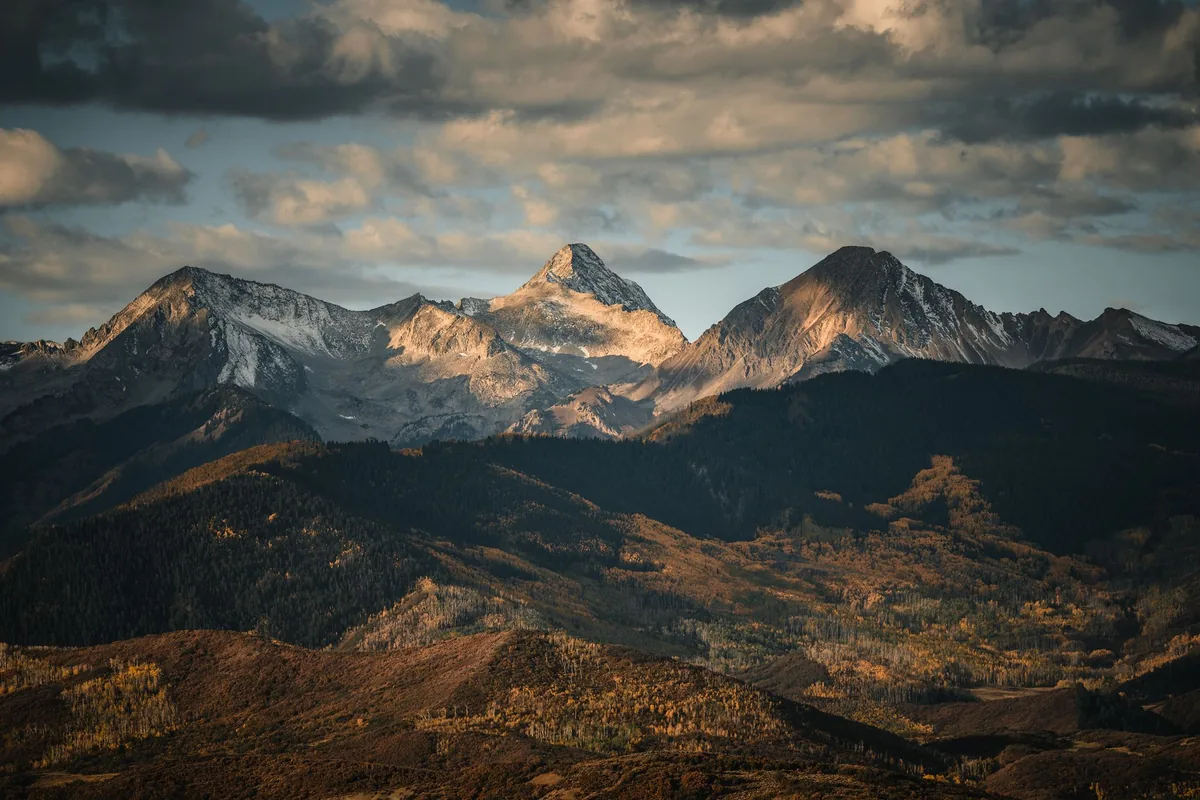 Snowcapped Elk Mountains peaks in golden light above Aspen