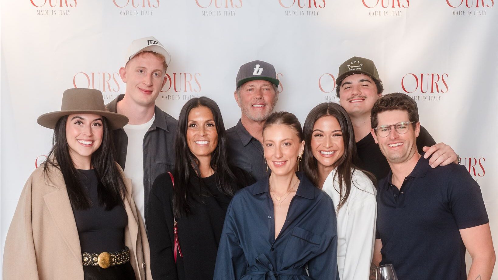 A large group of stylish guests posing together, featuring wide-brimmed hats and layered textures that represent communal Aspen luxury corporate event ideas.