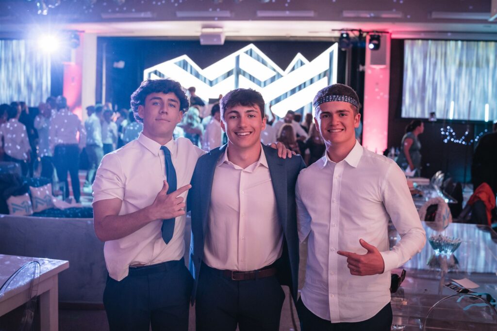Mitzvah guests smiling during photo roaming Aspen experience inside a luxury hotel ballroom