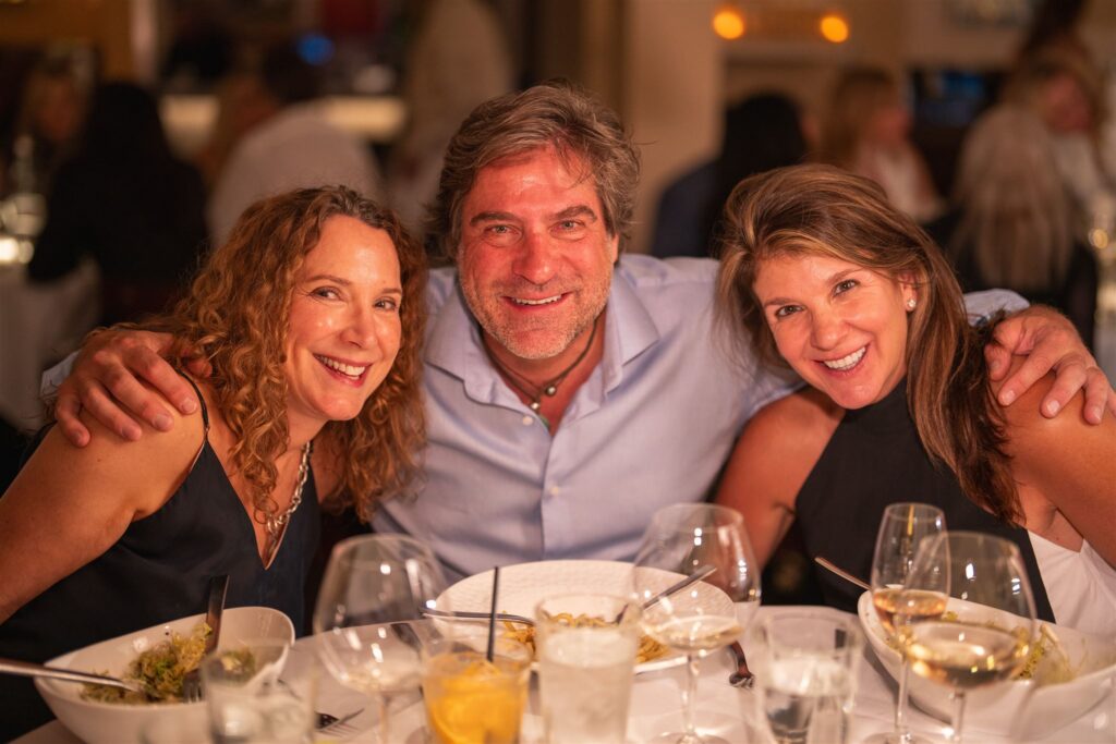 Smiling guests posing for photo roaming Vail inside a beautifully decorated luxury ballroom
