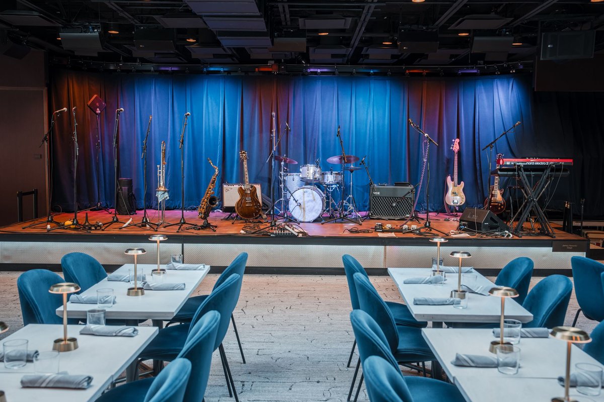 Paul JAS Center Aspen event photography showing the main stage with live band setup and blue velvet seating arranged before a performance