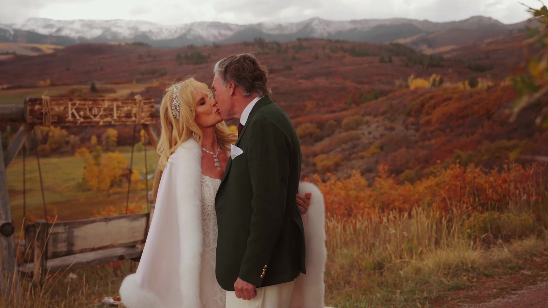 Bride and groom kiss in front of K and T ranch sign at McCabe Ranch wedding Old Snowmass Colorado